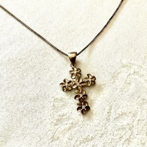 Sterling silver cross with flower detail. Marked​